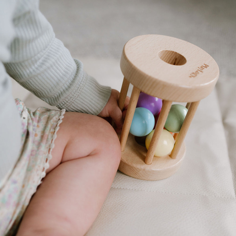 Wooden rolling rattle to encourage movement and build gross motor skills.
